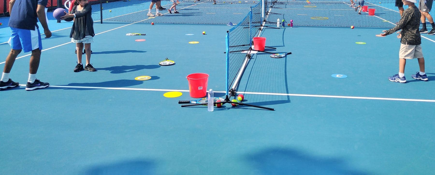 Kids at a group lesson on a mini court